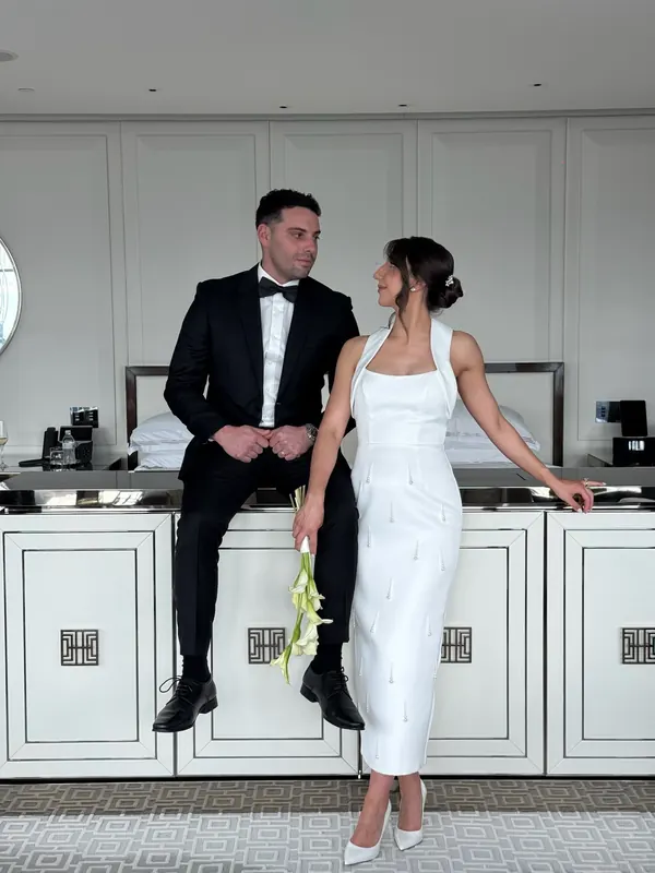Bride and groom in a hotel suite, her dark hair pinned into a low knot
