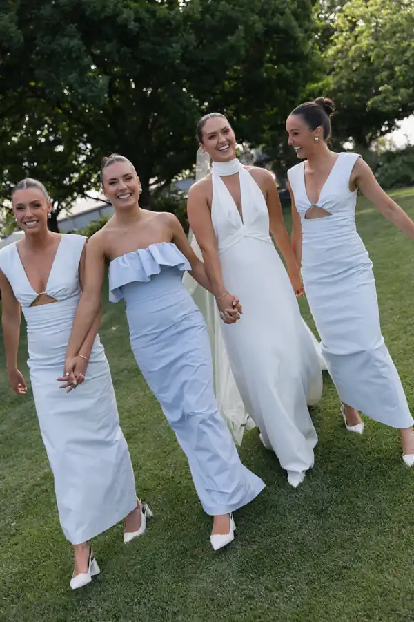 The bridesmaids walking across the lawn together, each one styled