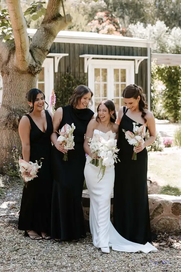 The bride with her party in black, hair worn down and finished