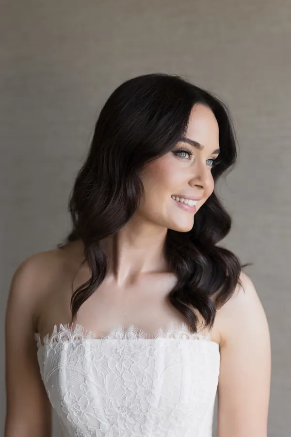 Dark hair in soft waves, worn down over a lace bodice